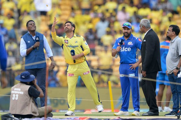 Chennai Super Kings' Mahendra Singh Dhoni (2L) throws a coin during the toss as Mumbai Indians' Rohit Sharma (3R) looks on before the start of the Indian Premier League (