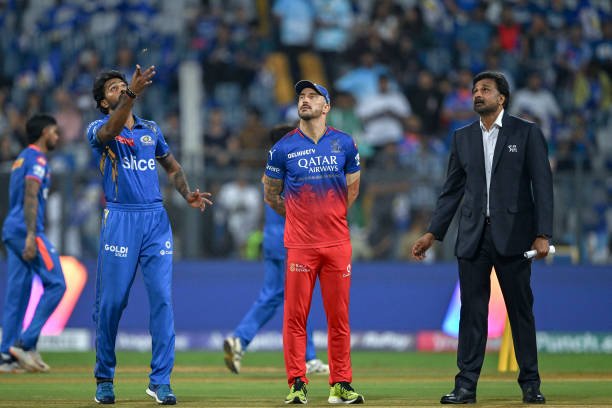 Mumbai Indians' captain Hardik Pandya tosses the coin as his Royal Challengers Bengaluru's counterpart Faf du Plessis (C) and Match Referee Javagal Srinath (R) watches before the start of the Indian Premier League 