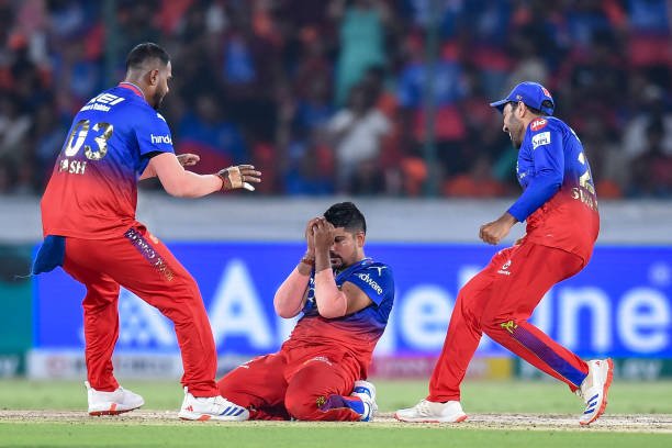 TOPSHOT - Royal Challengers Bengaluru's Karn Sharma (C) celebrates with teammates after taking the wicket of Sunrisers Hyderabad's Abdul Samad during the Indian Premier League (IPL) Twenty20 cricket match between Sunrisers Hyderabad and Royal Challengers Bengaluru at the Rajiv Gandhi International Stadium in Hyderabad