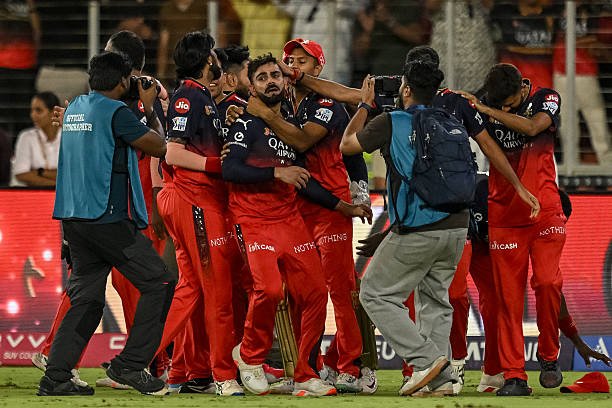 Royal Challengers Bengaluru's players embrace their teammate Virat Kohli (C) as they celebrate their team's win at the end of the Indian Premier League